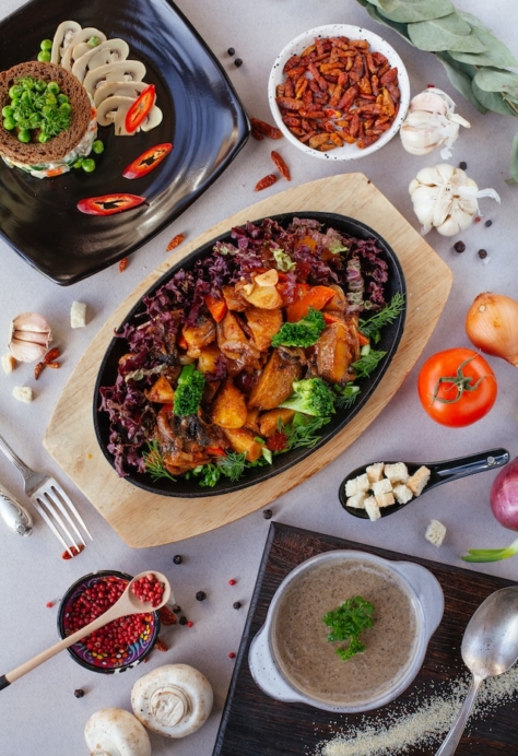 Et illustrasjonabilde av flere matretter lekkert dandert på et bord med hvit duk.